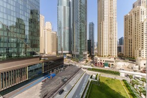 A modern urban area with high-rise buildings, a large parking lot, and a well-maintained green space.