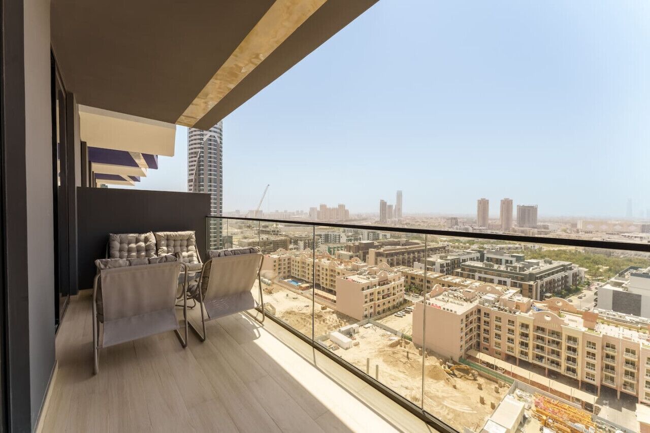 Un balcón con vistas a un paisaje urbano, que incluye edificios modernos y una obra en construcción.