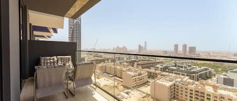 A balcony with a view of a cityscape, featuring modern buildings and a construction site.