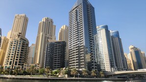 Un paisaje urbano con modernos rascacielos, una ribera y palmeras.