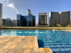 A swimming pool with a cityscape in the background.