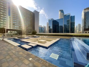 A swimming pool with geometric patterns and a cityscape in the background.