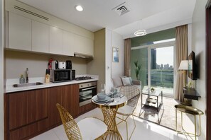 A modern kitchen with a dining area, a sofa, and a TV.