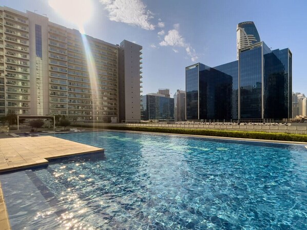 A swimming pool with a view of high-rise buildings in the background.