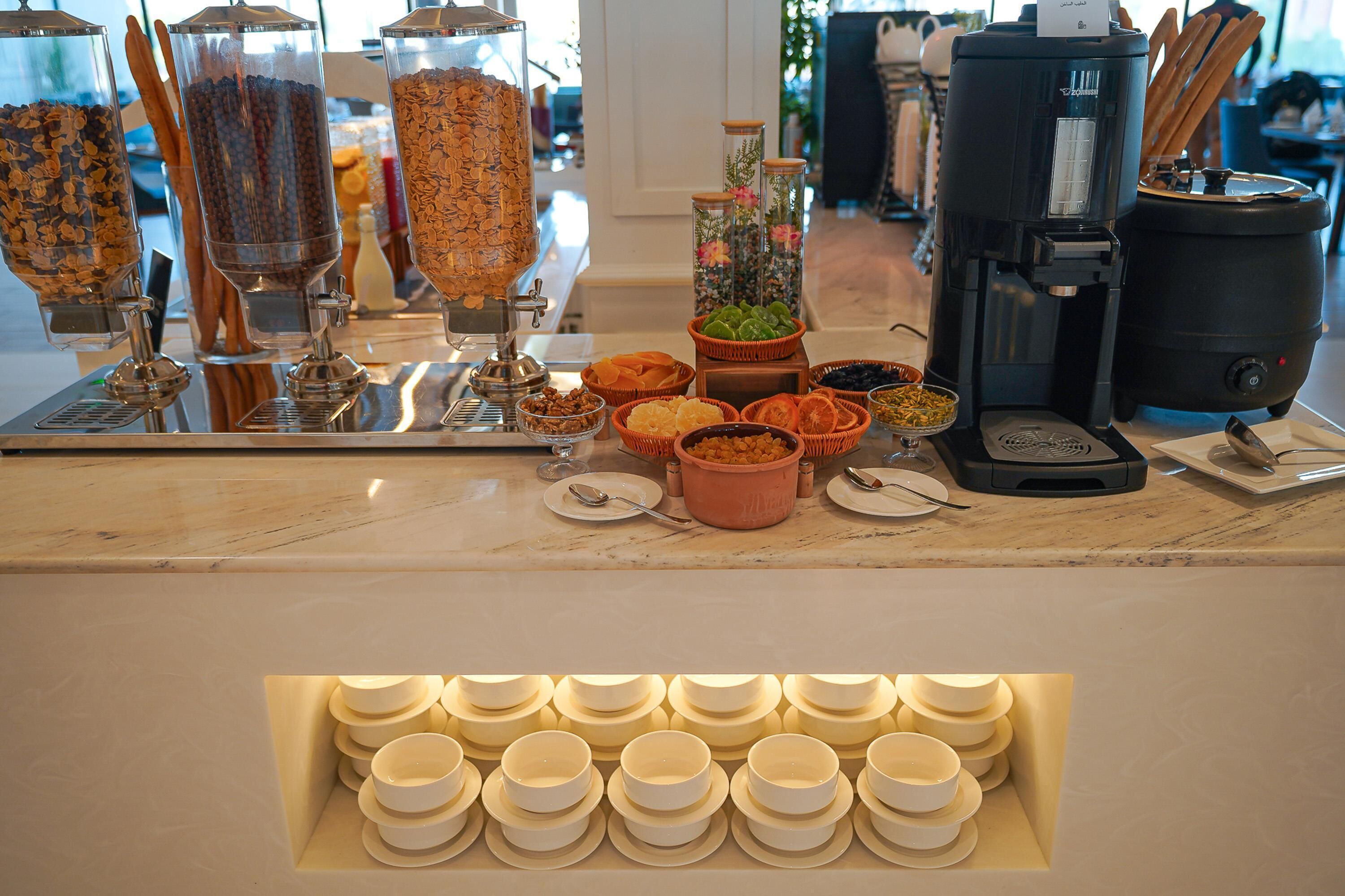 Un bufé de desayuno con diversas opciones de comida y una máquina de café.