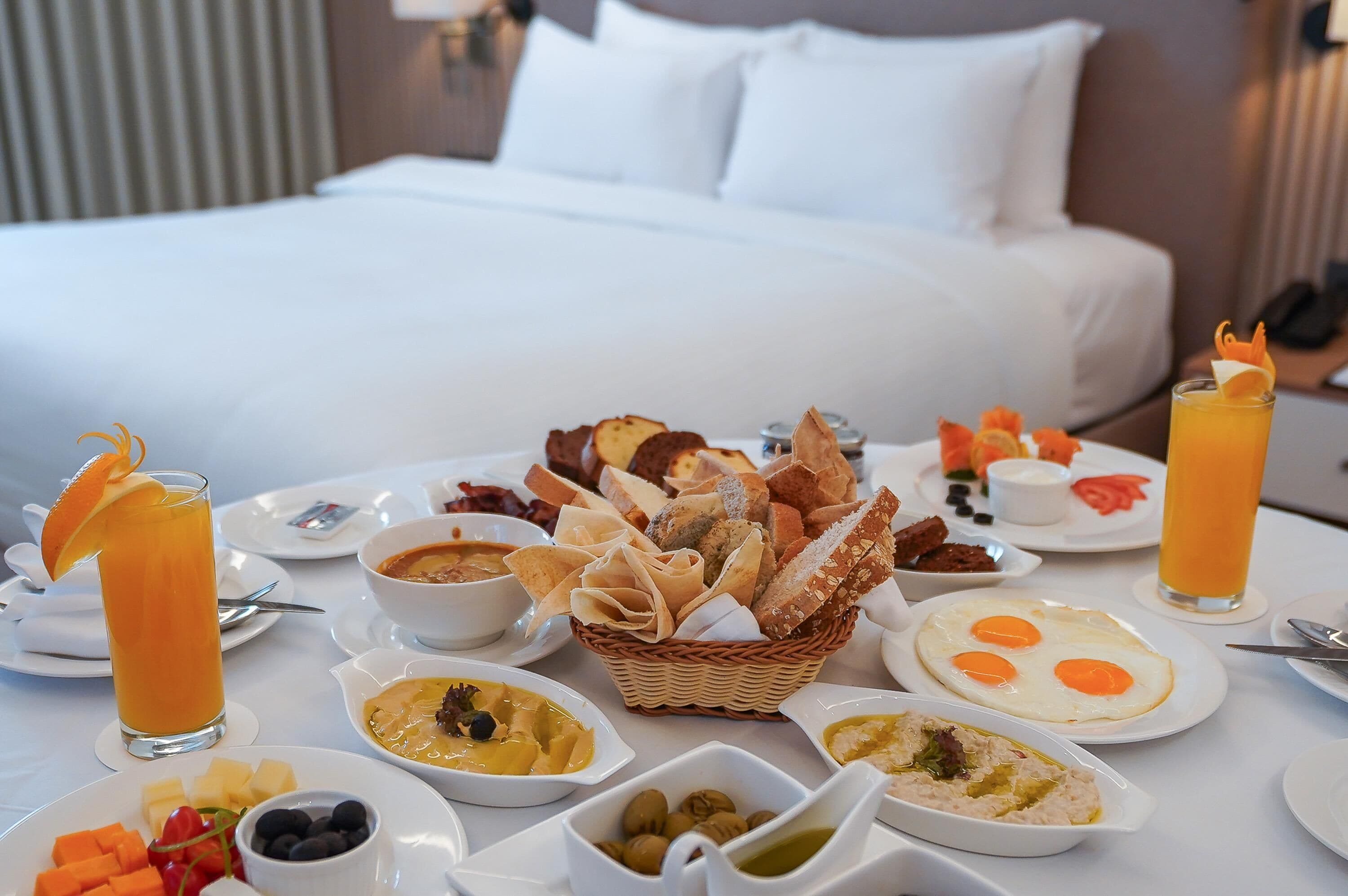 A breakfast buffet with various dishes and drinks on a table in a hotel room.