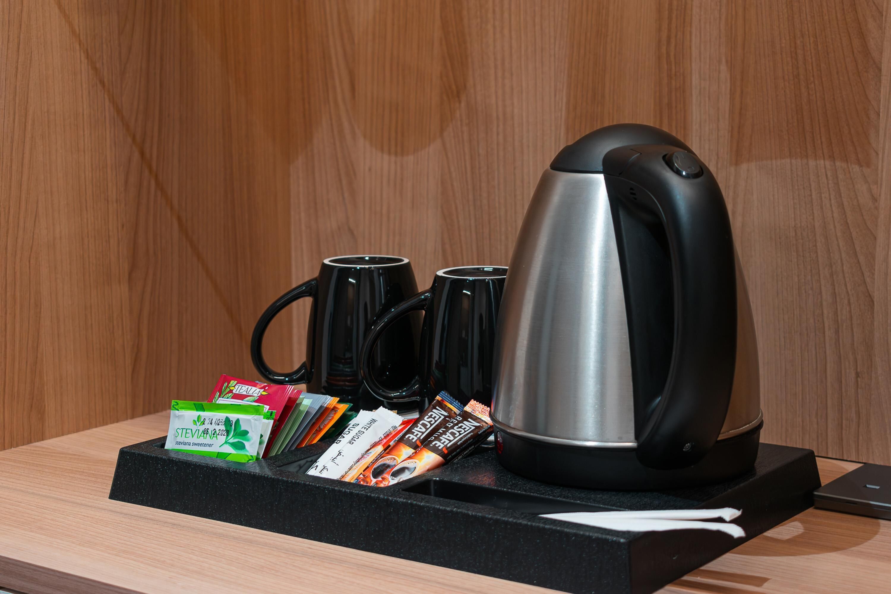 Un espace dédié au café, comprenant une machine à café, des tasses et des dosettes de café.