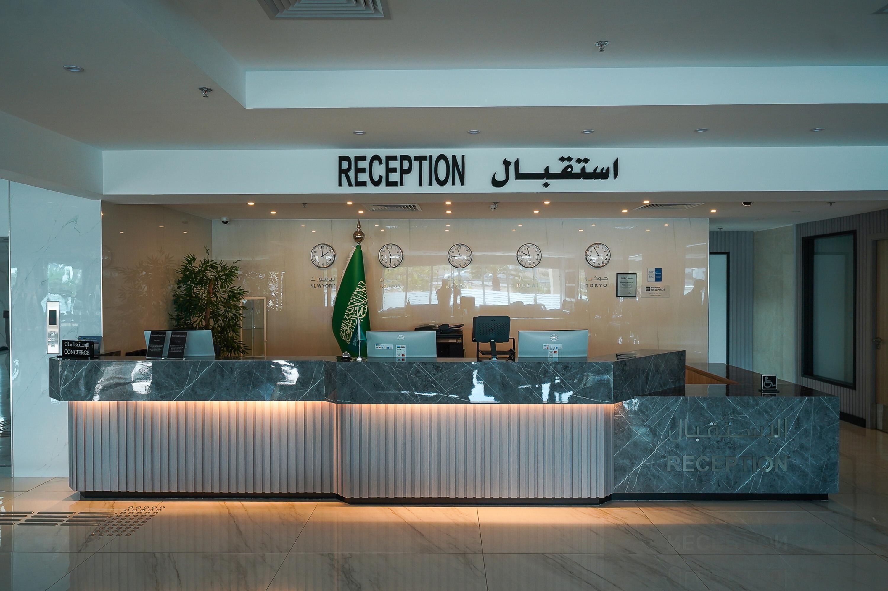 A reception desk with a modern design, featuring a marble top and a digital clock display.