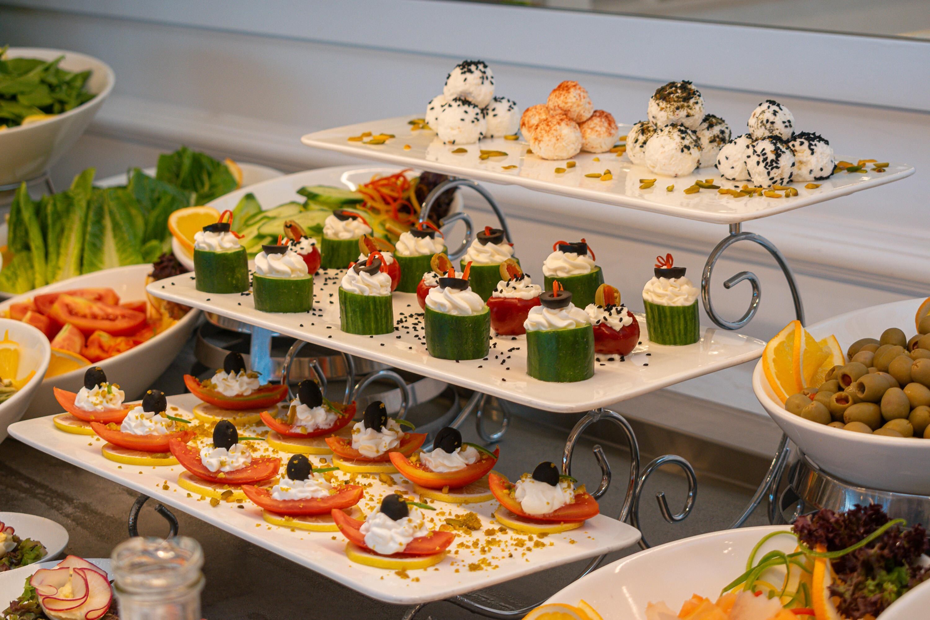 Un bufé con diferentes opciones de comida, incluyendo ensaladas, fruta y postres.