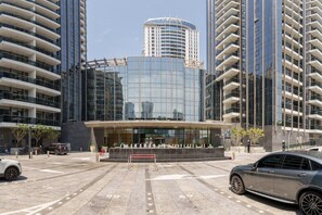 A modern building with a glass facade, surrounded by high-rise buildings.