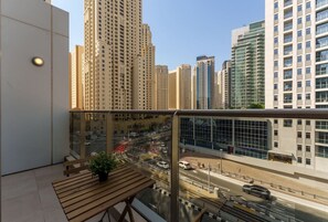A balcony with a view of a busy street and tall buildings.