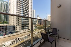 A balcony with a view of a cityscape, including tall buildings and a river.