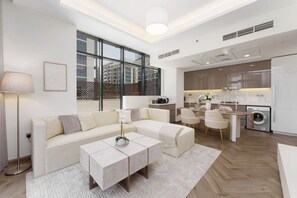 A modern living room with a sofa, coffee table, and dining area.