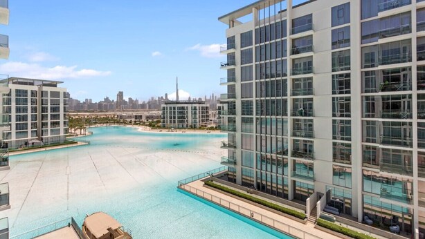 A modern building with a large pool, glass windows, and a view of the city skyline.