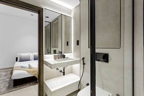 A modern bathroom with a large mirror, a sink, and a shower. - Stunnigly furnished and spacious apartment in JVC (Dubai)