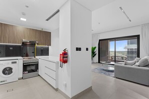 A modern apartment with a kitchen, a living area, and a balcony with a view. - Stunnigly furnished and spacious apartment in JVC (Dubai)