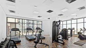 Une salle de sport équipée de tapis de course, de vélos elliptiques et de matériel de musculation.