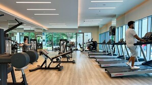 Ein Fitnessstudio mit Laufbändern, Krafttrainingsgeräten und Kurzhanteln.