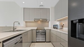 A modern kitchen with a built-in oven, a microwave, and a refrigerator.