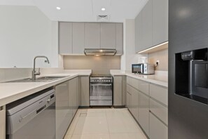 Una cocina moderna con horno integrado, microondas y refrigerador.