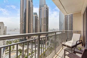 Un balcon offrant une vue sur des immeubles de grande hauteur et sur une étendue d’eau.