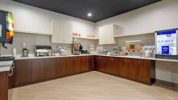 Een moderne keuken met houten kastjes, een koffieapparaat en een magnetron.