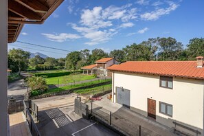 A residential area with a house featuring a red-tiled roof, a garage, and a fenced yard. - Apartment '4 Terraza - Antilles Sin Jardin' with Mountain View and Private Terrace (Llanes)