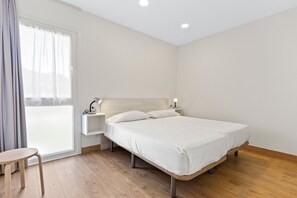 A bedroom with a bed, bedside tables, a chair, and a window with curtains. - Apartment '4 Terraza - Antilles Sin Jardin' with Mountain View and Private Terrace (Llanes)