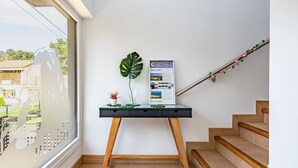 Ein Schreibtisch mit Pflanze, einem Poster und einer Treppe.
