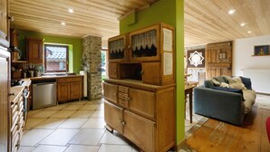 A kitchen with wooden cabinets, a stone wall, and a green accent wall.