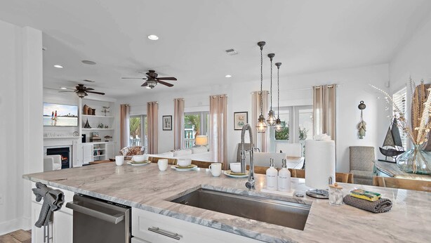 A modern kitchen with a large island, built-in appliances, and a view of the outdoors.