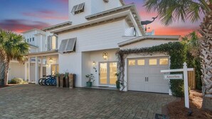 A two-story house with a garage, a driveway, and a sign reading "AmorSea".