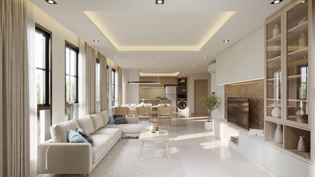 Una sala moderna con un sofá, una mesa de centro y un televisor. Se ve una cocina al fondo con una zona de comedor.