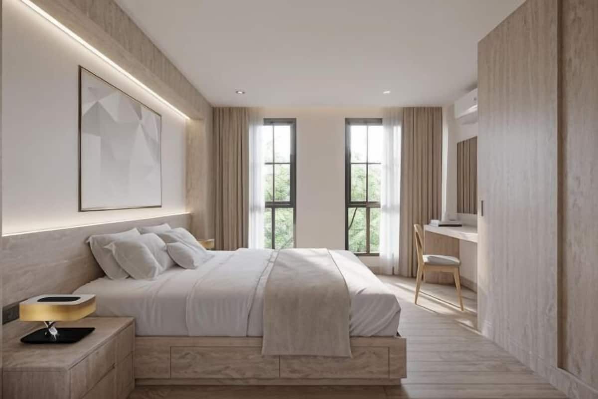 A modern bedroom with a large bed, bedside tables, a desk, and a chair.