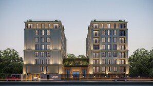 Un edificio moderno con fachada simétrica, múltiples ventanas y una entrada central.