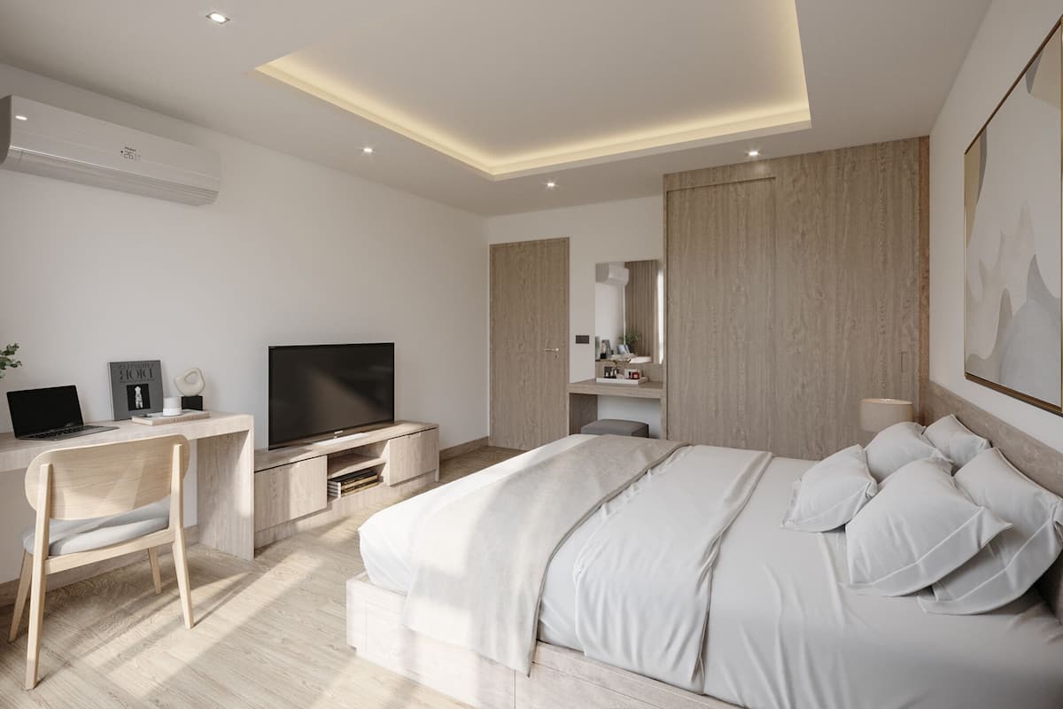 A modern hotel room with a bed, desk, and television.