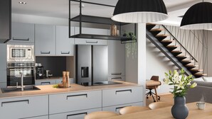 A modern kitchen with grey cabinets, a wooden countertop, and a built-in oven. - Villa Pinea (Zadar)