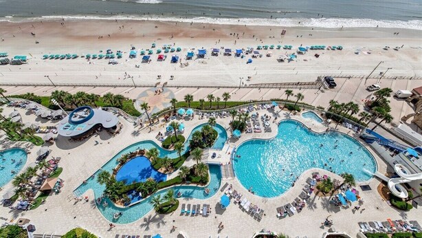 A resort with multiple swimming pools, beach access, and lounge areas. - Horizon Hideaway - Ocean Walk (Daytona Beach)