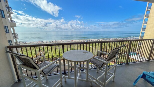 Un balcon avec vue sur la plage et l’océan.