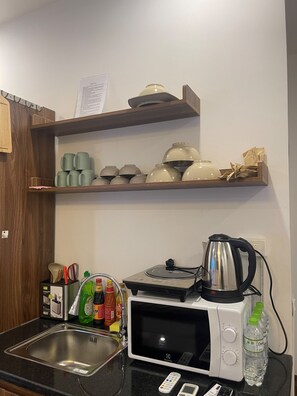 Frigorífico pequeño, microondas, placa de cocina y utensilios de cocina
