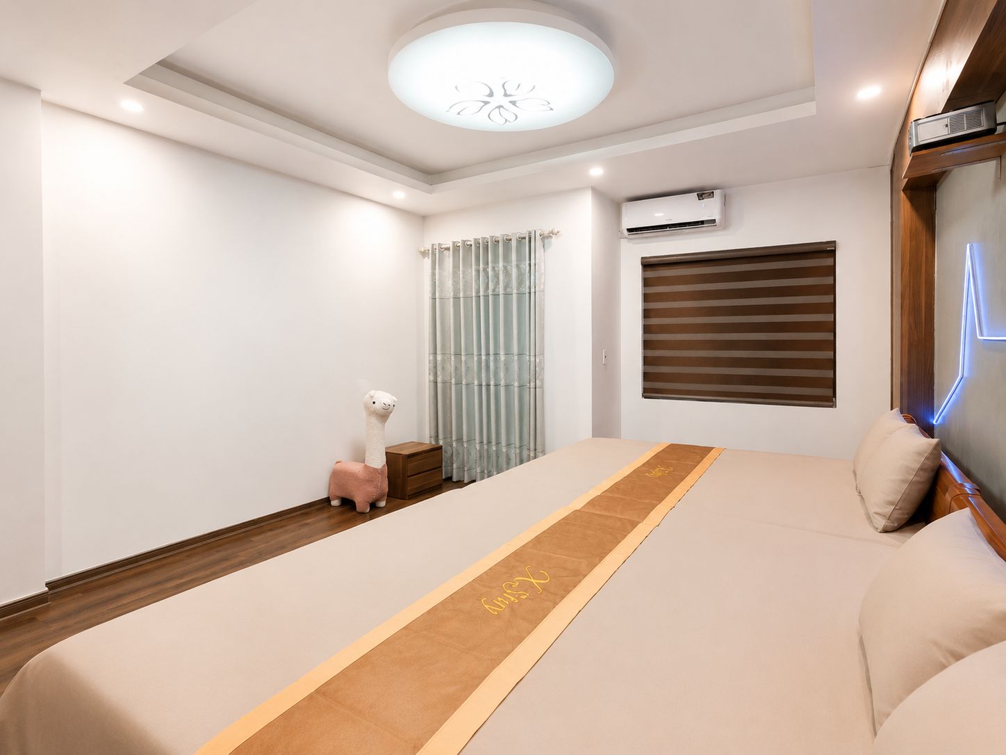 A modern bedroom with a bed, a nightstand, a lamp, and a window with blinds.
