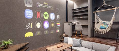 A modern living room with a sofa, a wooden coffee table, a hanging chair, and a wall with various service icons.