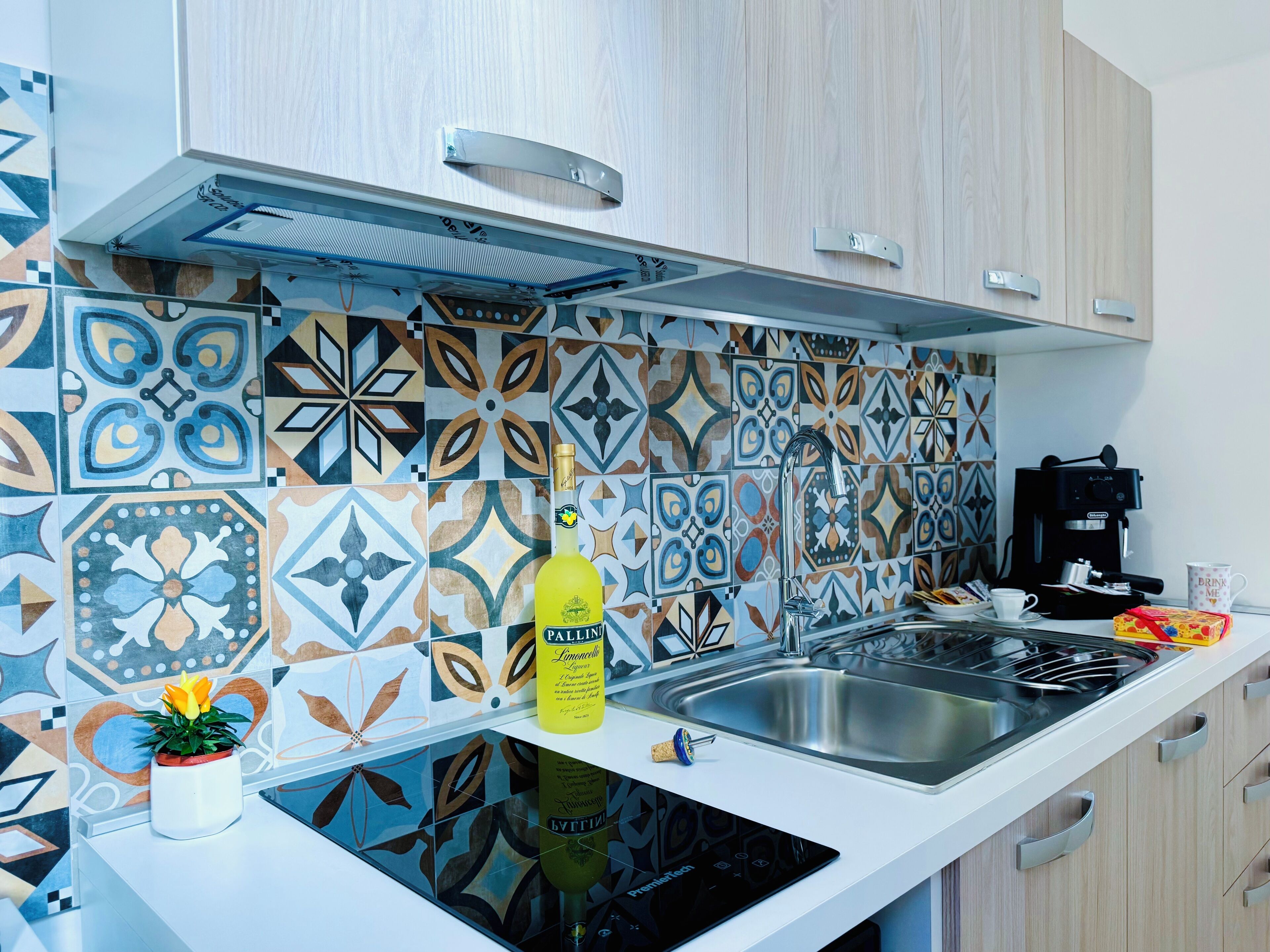 Une cuisine moderne avec des carreaux décoratifs, une machine à café et une bouteille de liqueur Ballina.