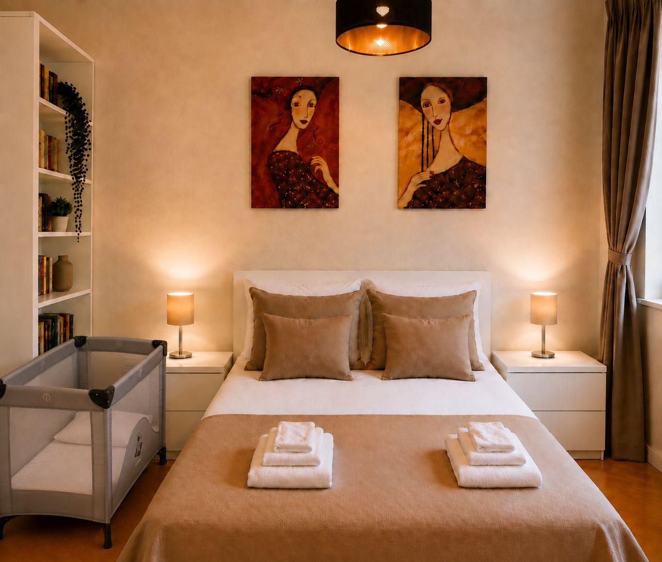 Una camera d'albergo con un letto, due lampade da comodino, una libreria e due quadri appesi al muro.