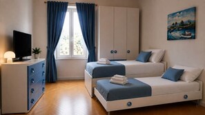 Una camera da letto con due letti, una TV, una cassettiera e un quadro appeso al muro.
