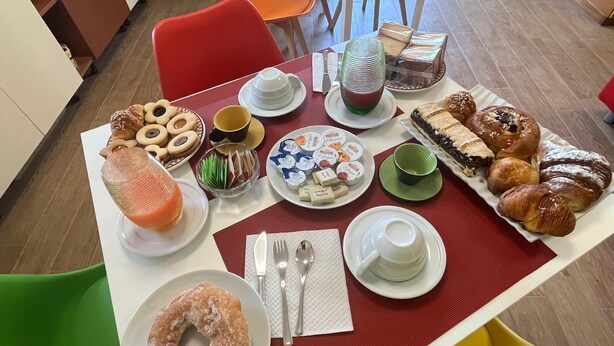 Un buffet de petit-déjeuner proposant un assortiment de viennoiseries, de gâteaux et de boissons.