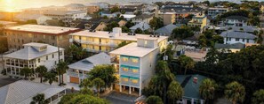 Un quartier résidentiel situé sur la côte, avec des immeubles à plusieurs étages, dont certains sont dotés de balcons, et entouré de palmiers.