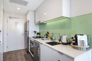 Eine moderne Küche mit Gasherd, Spüle und Kaffeemaschine.