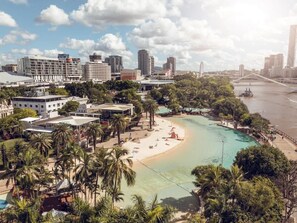 Eine Küstenstadt mit Strand, Palmen und modernen Gebäuden.