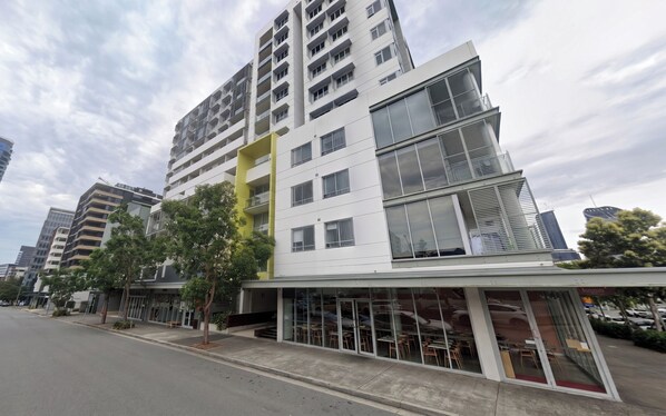 Un immeuble à plusieurs étages doté d’une architecture moderne, caractérisé par un mélange de balcons et de grandes fenêtres.